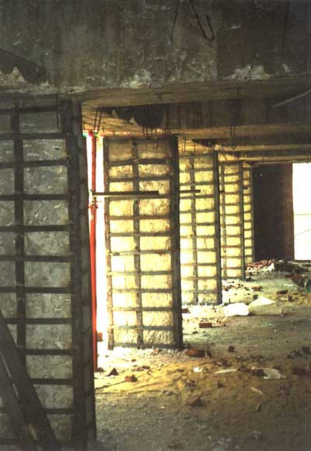 A reinforced concrete column strengthened in place with steel angles and welded strips.